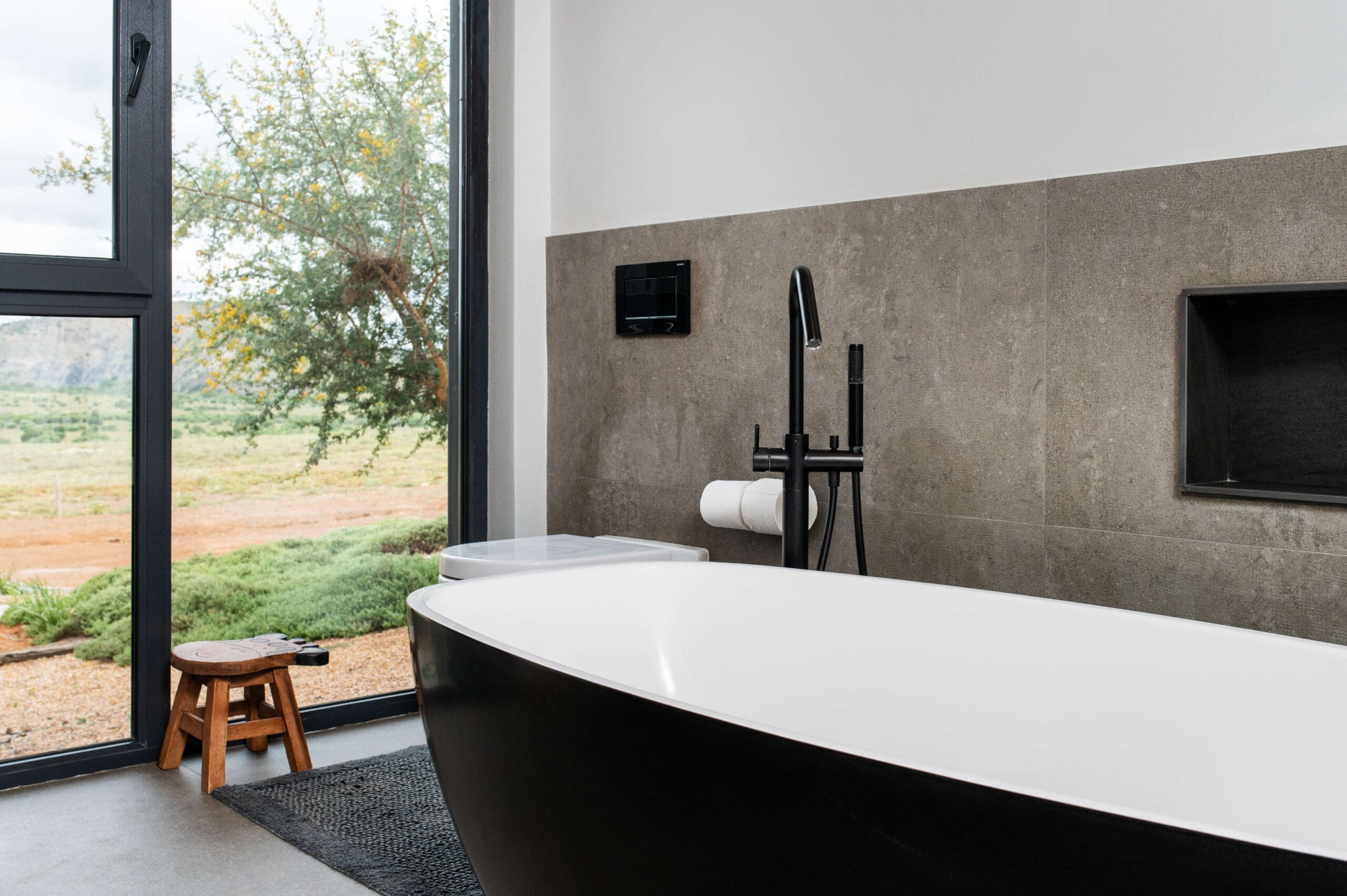 Modern bathroom with a window framing a picturesque mountain landscape.