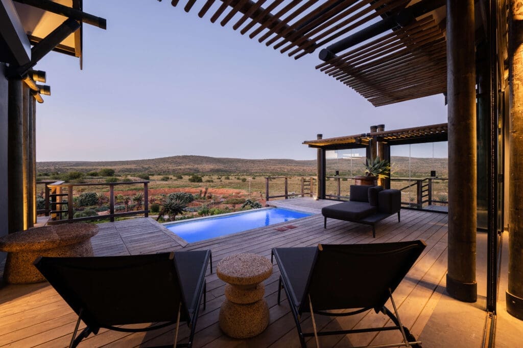 Sunset paints the sky as you relax by the pool, overlooking the mountains.