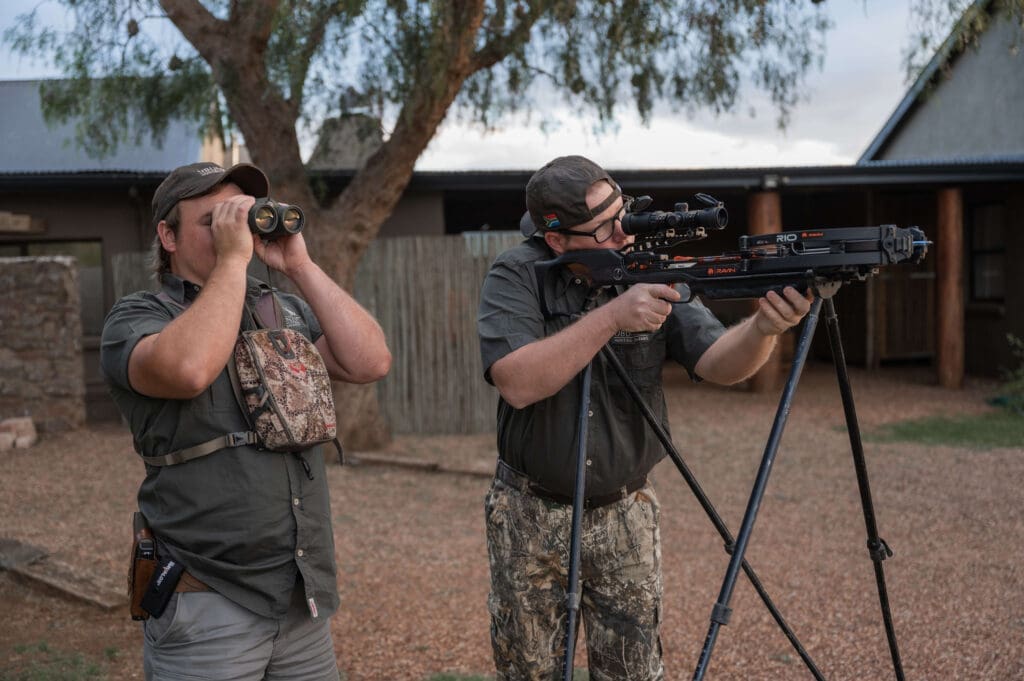 Close-up of a hunter with a rifle, looking through the scope.